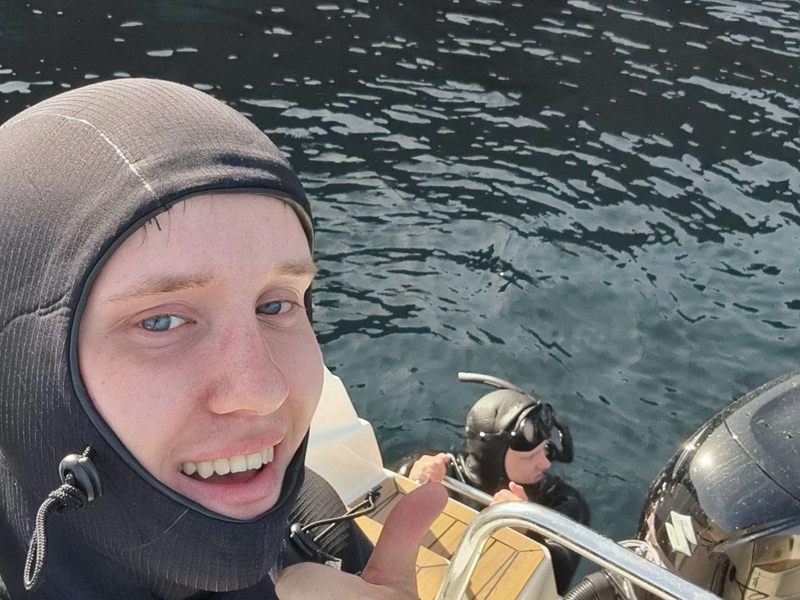 Sivert i våtdrakt gir tommel opp fra en båt